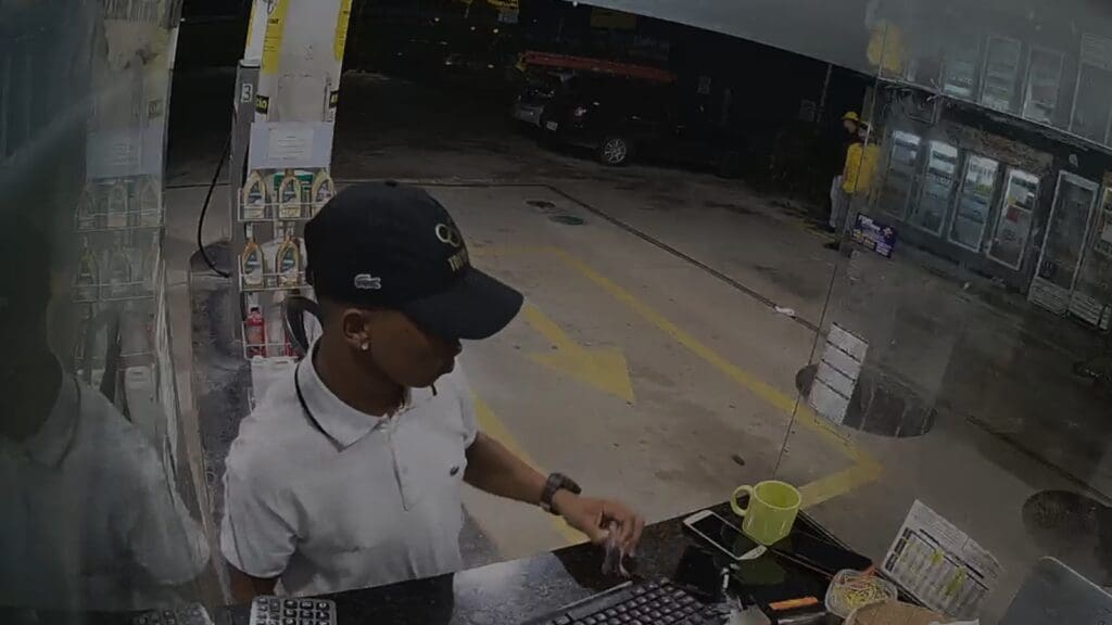 Foto homem com bone roubando um posto de gasolina