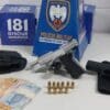 Sobre uma mesa branca uma pistola, uma arma falsa,10 munições além de R$ 427 em dinheiro