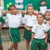 Foto de um grupo de 6 crianças vestidas com os novos uniformes escolares fazendo pose para a foto da divulgação do kit escolar