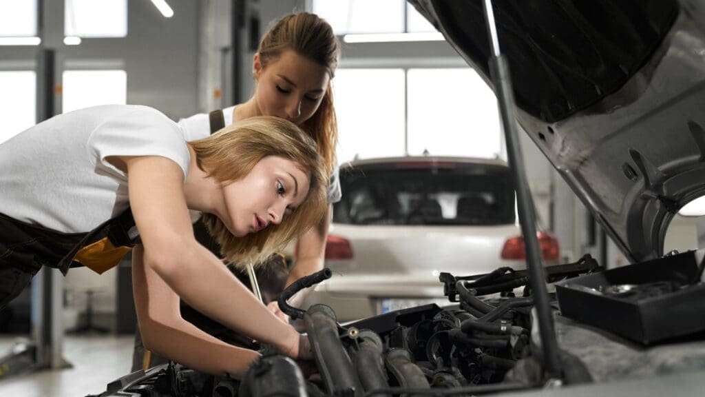 Duas mulheres observando motor do carro