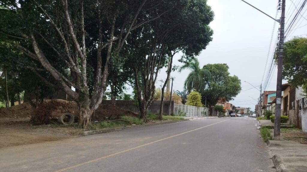 Foto de uma rua no bairro Barcelona na cidade da Serra, do lado esquerdo um terreno com arvores e vegetação onde foi encontrado, um bebe.