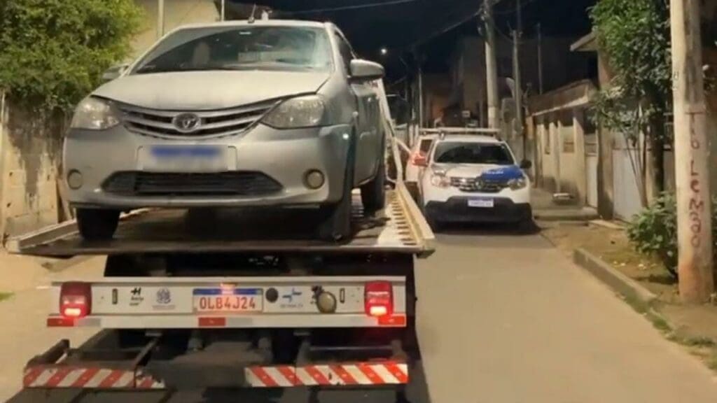 Foto de um veículo Toyota Etios, em cima de um guincho durante uma ocorrência de veículo roubado.