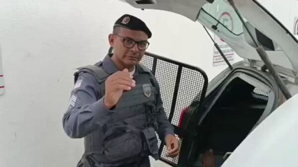 Foto do Sargento Mauricio entrevistando um detido ainda na gaiola de uma viatura.