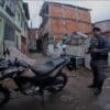 Foto do Cabo Marques da Policia Militar em um beco ao lado de uma motocicleta com restrição de furto/roubo