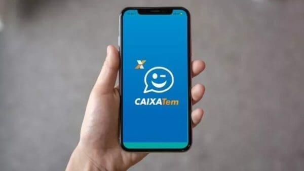 Foto de uma pessoa segurando o celular aberto no aplicativo do CaixaTem