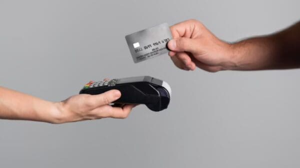 Foto de uma pessoa passando o cartão de crédito