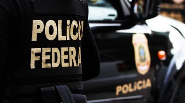 Foto de um agente da Polícia Federal de costas com um destaque em o nome da Polícia Federal do seu uniforme