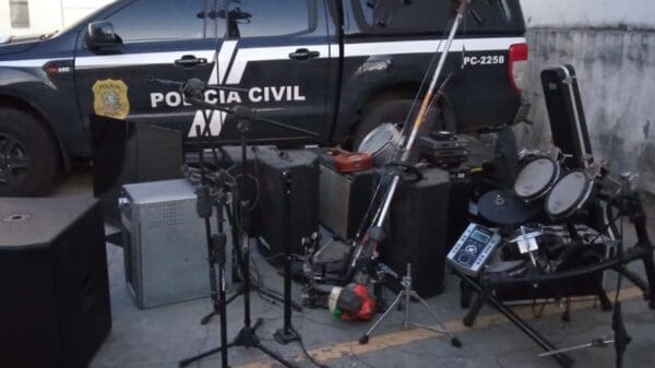 Foto com uma viatura da Polícia Civil e instrumentos musicais, recuperados apos serem roubados de um sitio