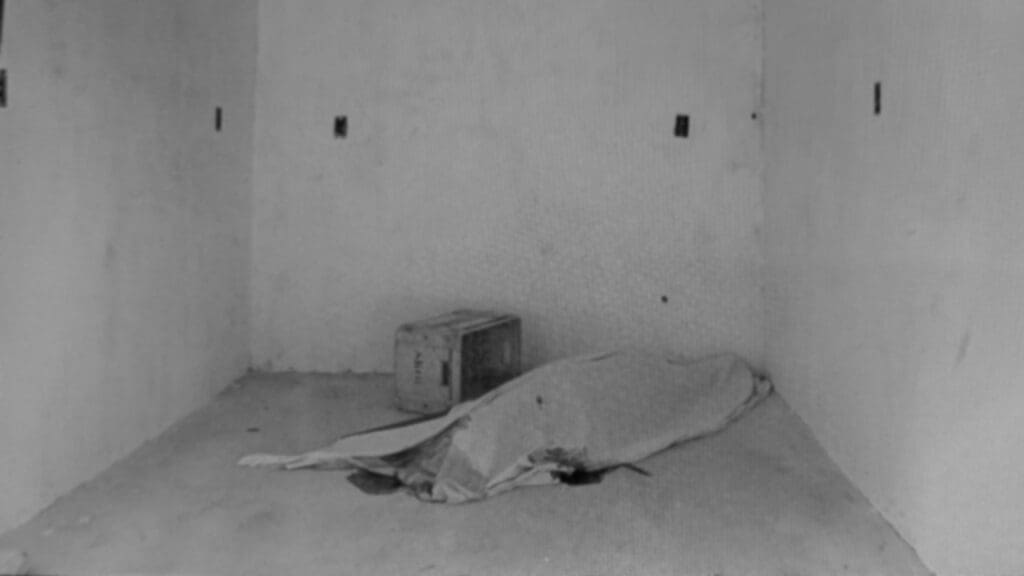 Foto em preto e branco de um corpo em um comodo de uma obra