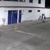 Imagem de camera de segurança mostrando uma rua com dois jovens em bicicletas assaltando uma adoescente