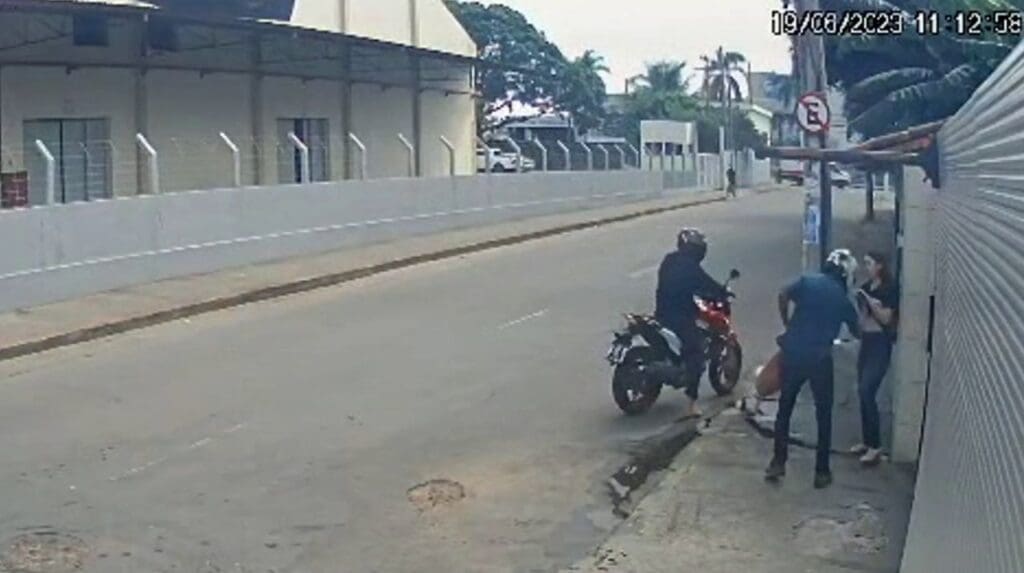 Imagem de câmera de segurança flagram dois homens em uma motocicleta cercando a vitima e roubando seus pertences em plena luz do dia em uma via movimentada de Jardim Limoeiro na Serra