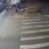 Imagens de uma câmera de segurança em um cruzamento logo após um assaltante sofrer um acidente de moto e ficar caído na calçada, na imagem há um ônibus passando pelo local e algumas pessoas em volta da vitíma.