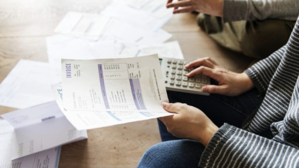 Foto de uma pessoa calculando as dívidas