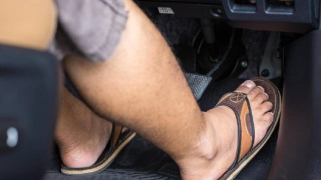 Foto de uma pessoa dirigindo usando o chinelo