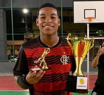 Gabriel, goleiro do Flamengo Futsal segura troféus 
