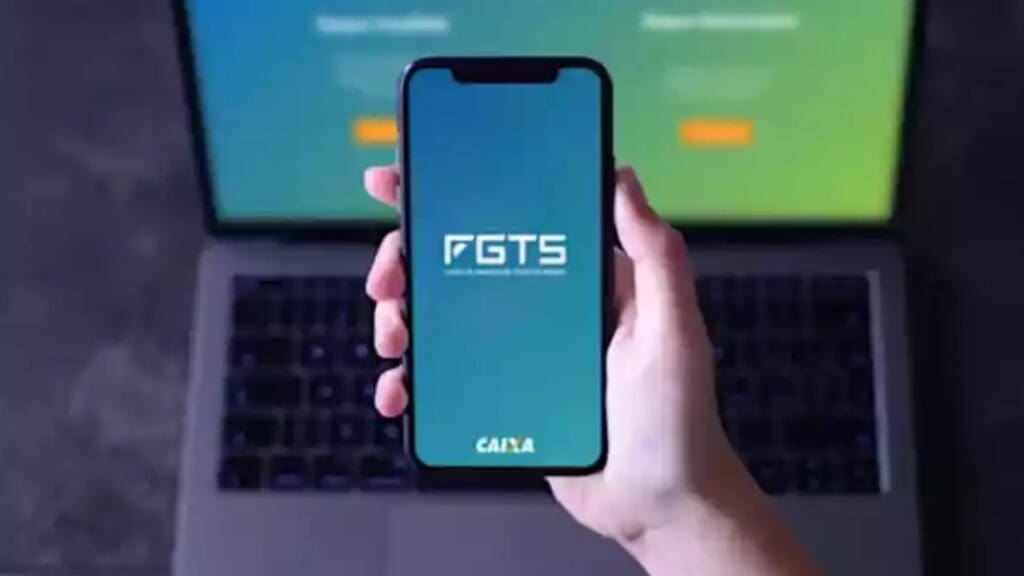 Foto de uma pessoa segurando um celular aberto no aplicativo do FGTS