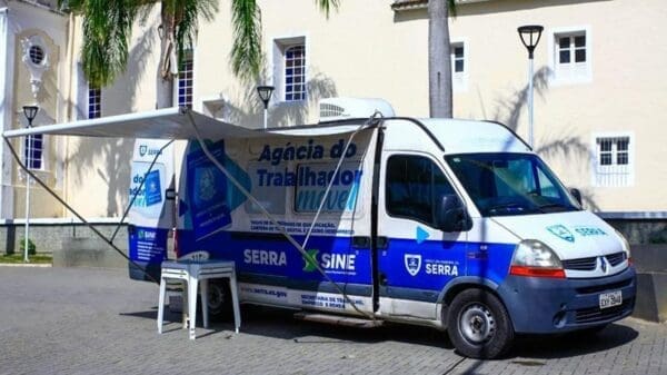 uma van da prefeitura da Serra, estacionada em frente a um prédio aguardando os candidatos a vagas de emprego.