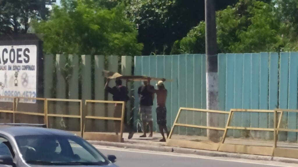 Foto com um trio de dependentes quimicos, furtando uma placa de proteção na Rodovia Norte Sul.