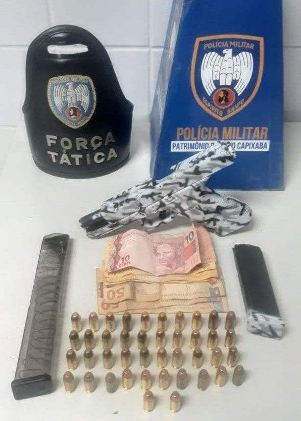 Sobre uma mesa branca, uma pistola .40, 42 munições do mesmo calibre, dois carregadores, além de R$250,00 em espécie.