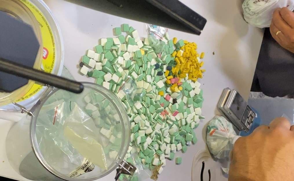 sobre uma mesa milhares de ecstasy's  apreendidos durante a ocorrência do laboratório do tráfico