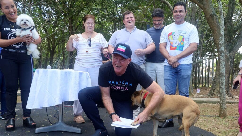 Governador Renato Casagrande assinando o Programa Estadual de Bem-Estar Animal junto com um cão