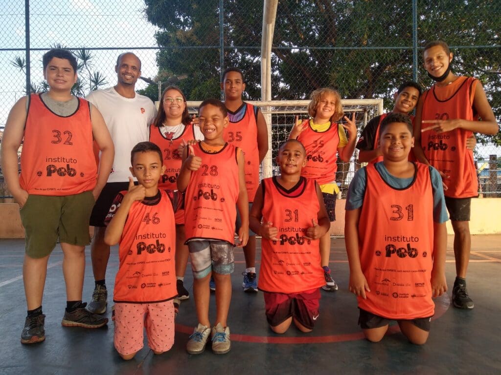 Instituto PEB jovens em uma quadra usando uniforme de basquete pousando para a foto. 
