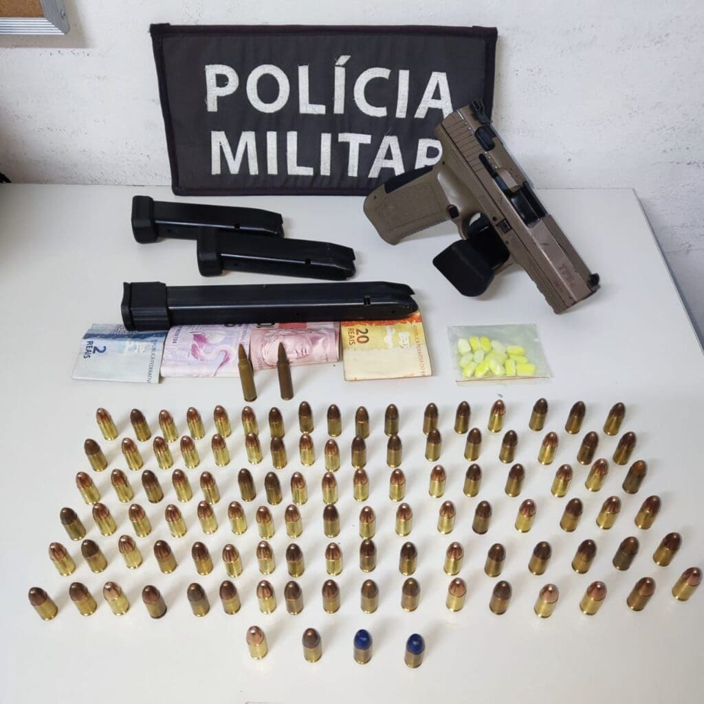 Sobre uma mesa na Delegacia Regional uma pistola 9mm, um envelope com comprimido de ecstasy, várias munições de 9mm, 2 de fuzil, 3 carregadores, além R$ 400 em espécie.