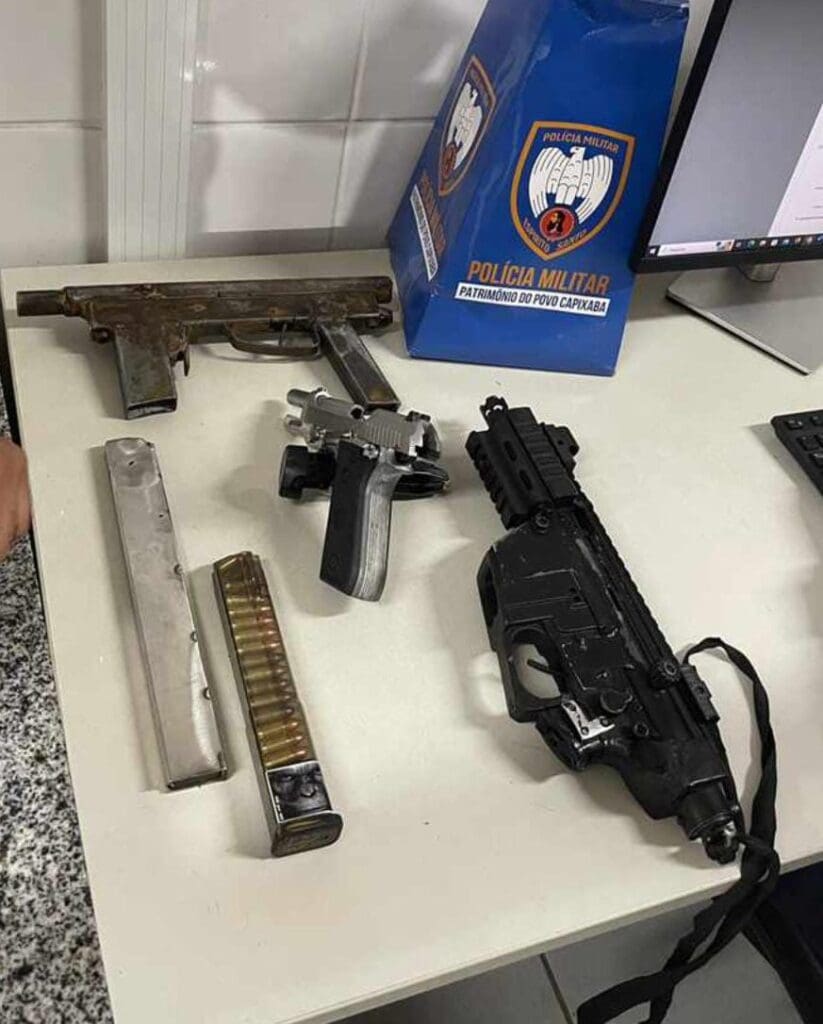 Armas apreendidas de posse da quadrilha, sobre uma mesa uma pistola carregadores, e duas armas de fabricação caseira.