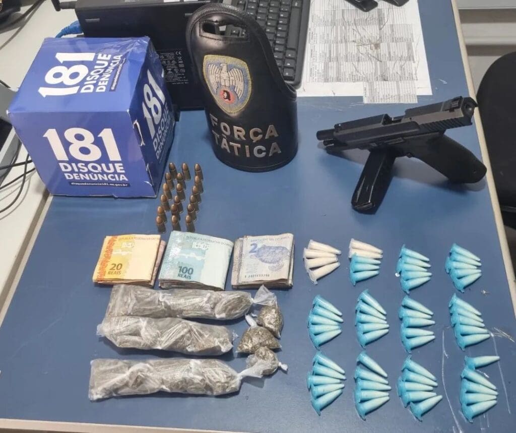 Materiais apreendidos pela equipe da Força Tatica sobre uma mesa uma pistola calibre 9mm com 18 munições, 59 pinos de cocaína, 45 buchas de maconha, além de R$ 753 em espécie.