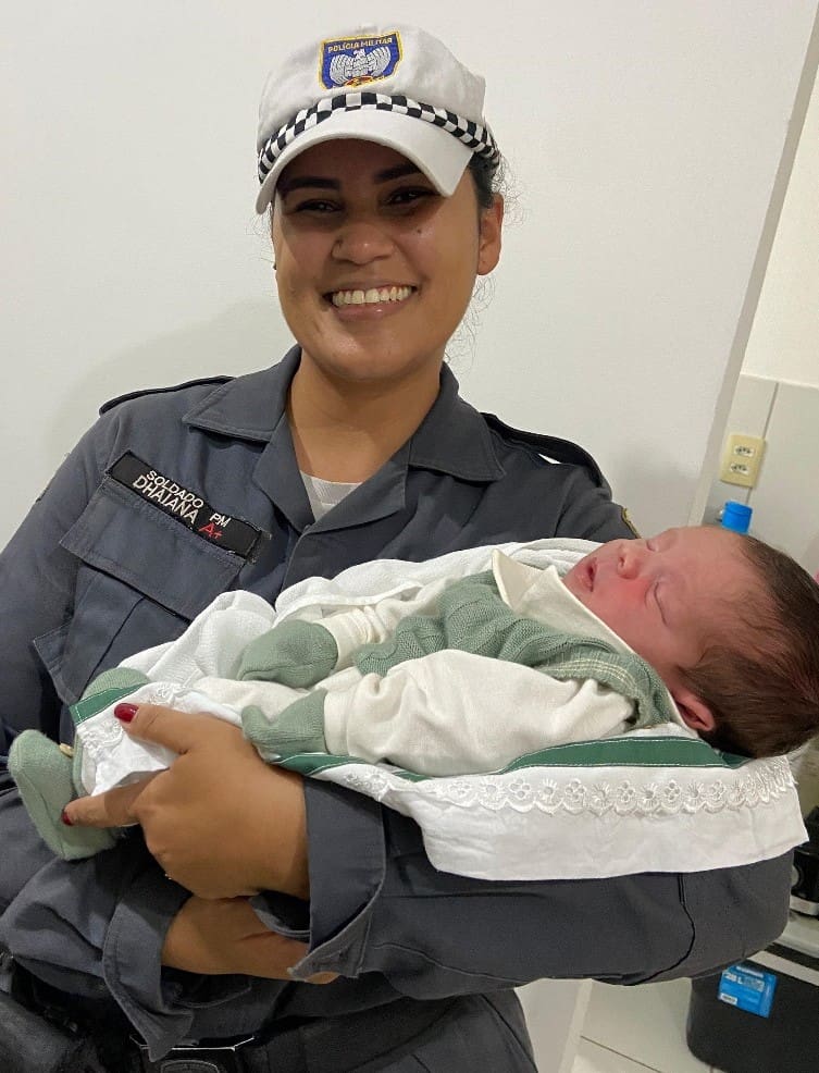 A Soldado Dhaiana do Batalhão de Polícia de Trânsito, segurando um bebê.