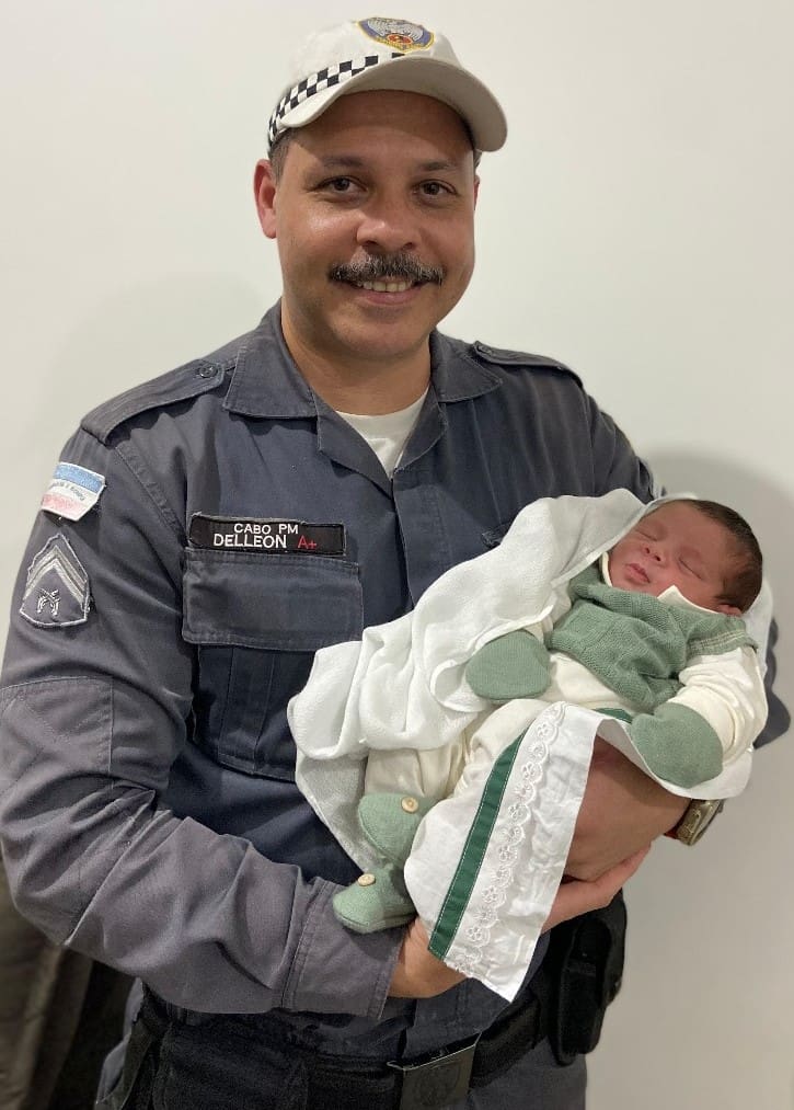 cabo do Batalhão de Polícia de Trânsito Delleon, segurando um bebê.