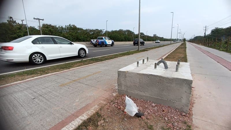 Imagem de uma base de concreto, no canteiro central de uma rodovia, com veículos trafegando na pista.