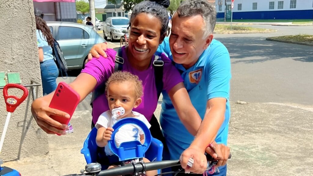 Candidato a prefeito da Serra, Audifax Barcelos, ao lado de uma ciclista com seu filho. (Foto: reprodução Facebook)