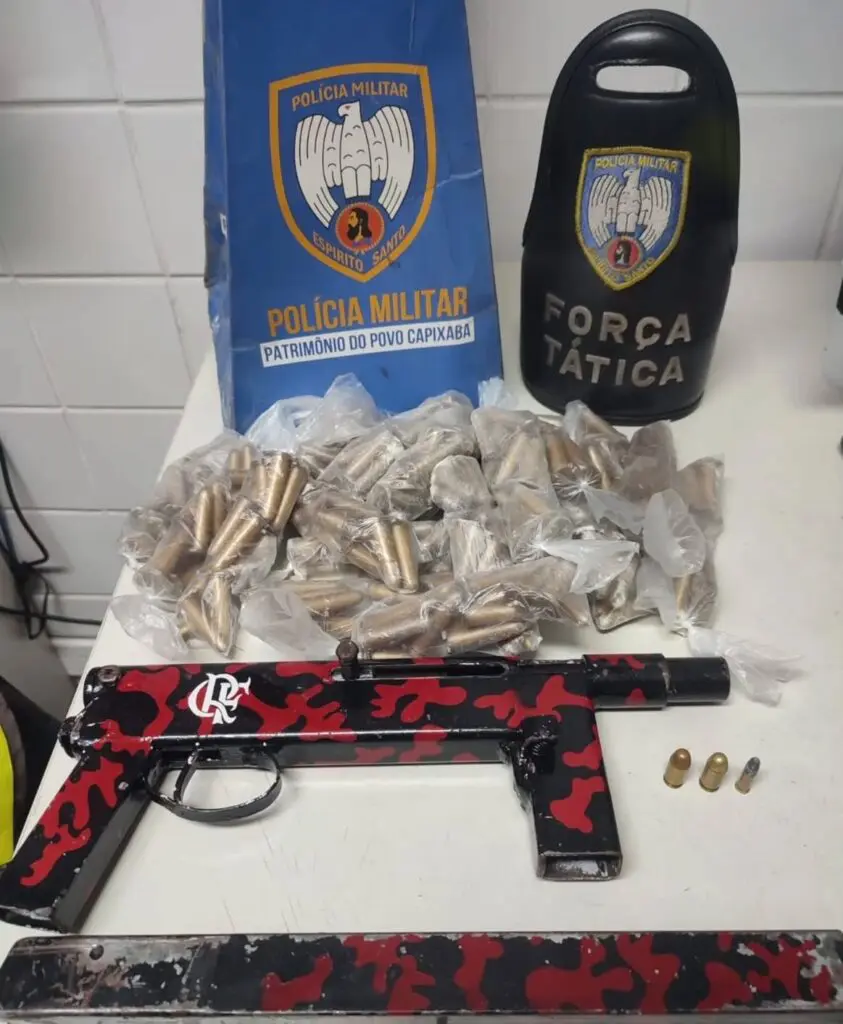 Sobre uma mesa uma metralhadora de fabricação caseira, calibre 380, munições e 268 pinos de cocaína.