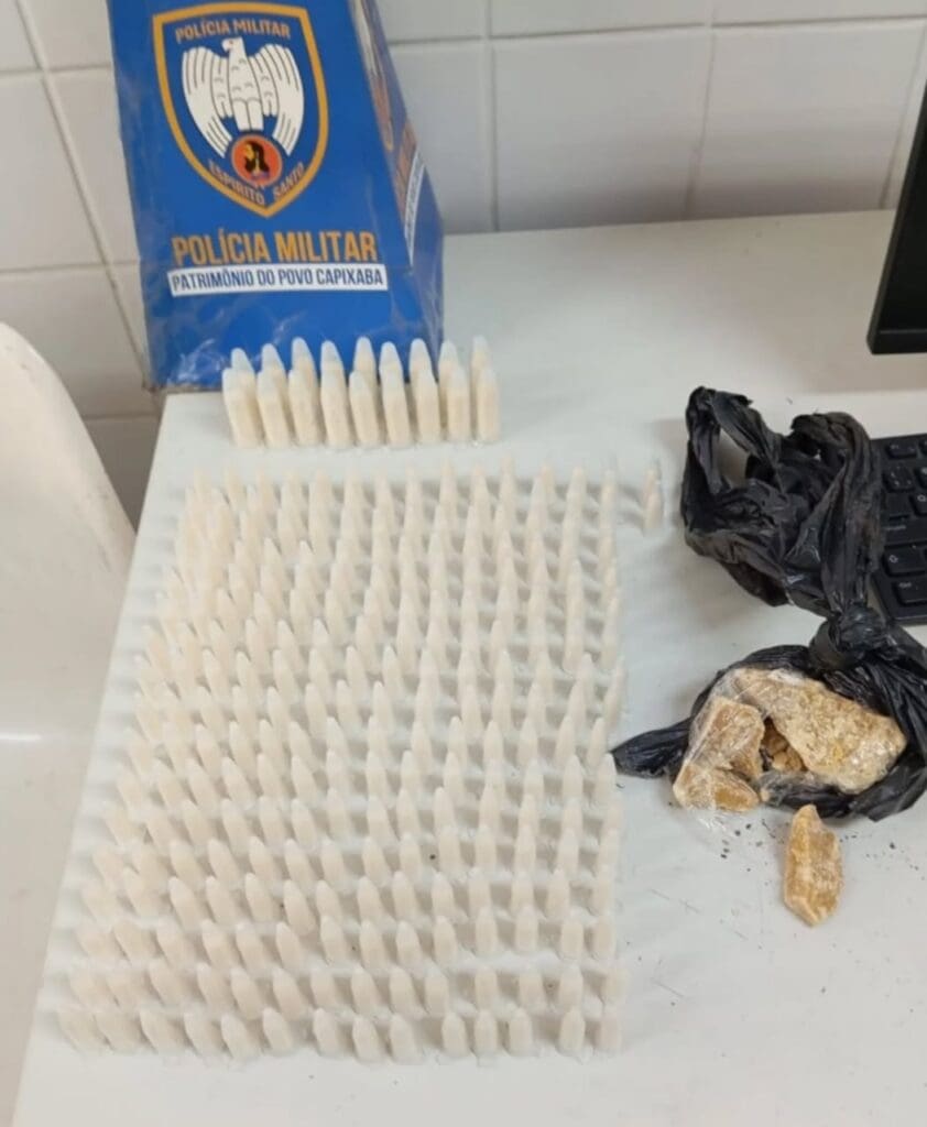 Imagem de uma apreensão da Polícia Militar, sobre uma mesa 258 pinos de cocaína e 50 gramas de crack, que foram encontradas com um traficante.