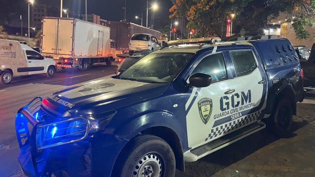 Uma viatura da Guarda da Serra estacionada em uma calçada, e no fundo alguns veículos trafegando em uma via.