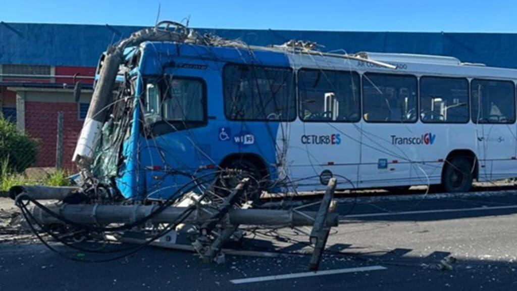 Ônibus do Transcol acidentado na Avenida Talma Rodrigues, na Serra, com poste derrubado e fios espalhados na via.