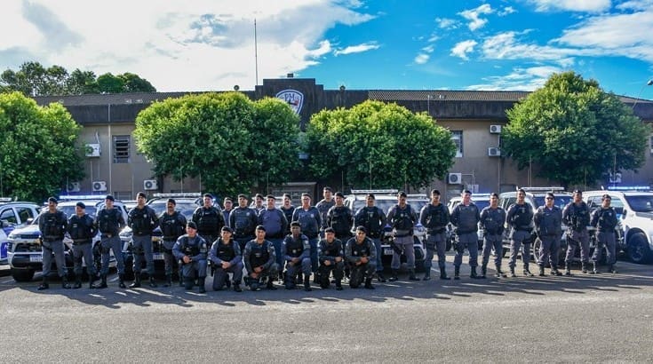 Imagem de um patio com um grupo de policiais militares posando para foto em frente a nova frota de viaturas.