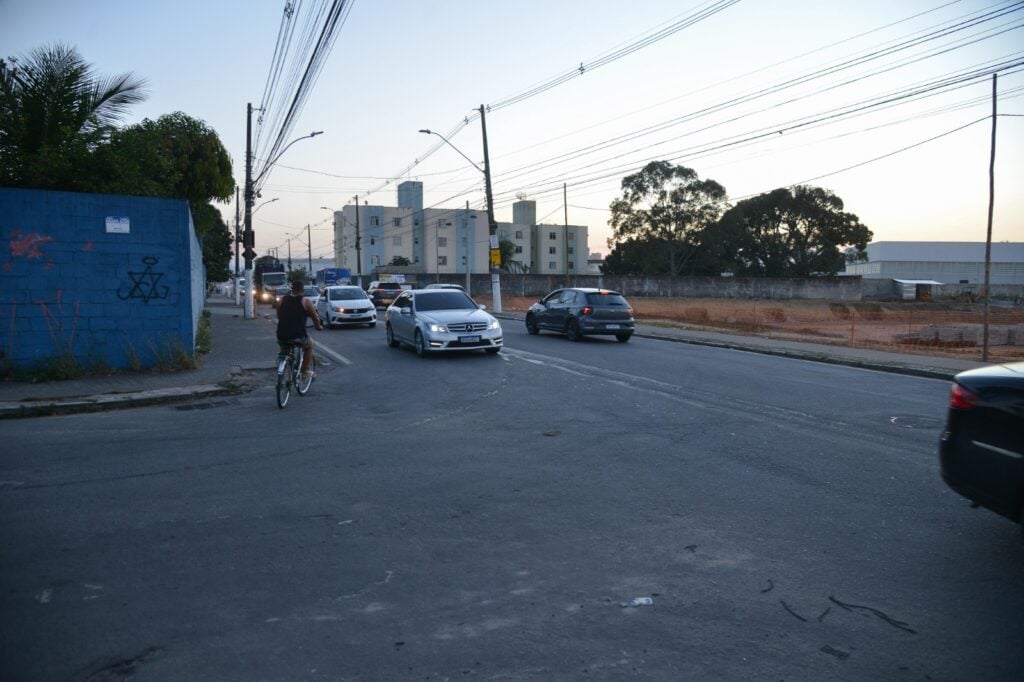 Imagem de uma avenida com carros trafegando em duas pistas em direções diferentes.