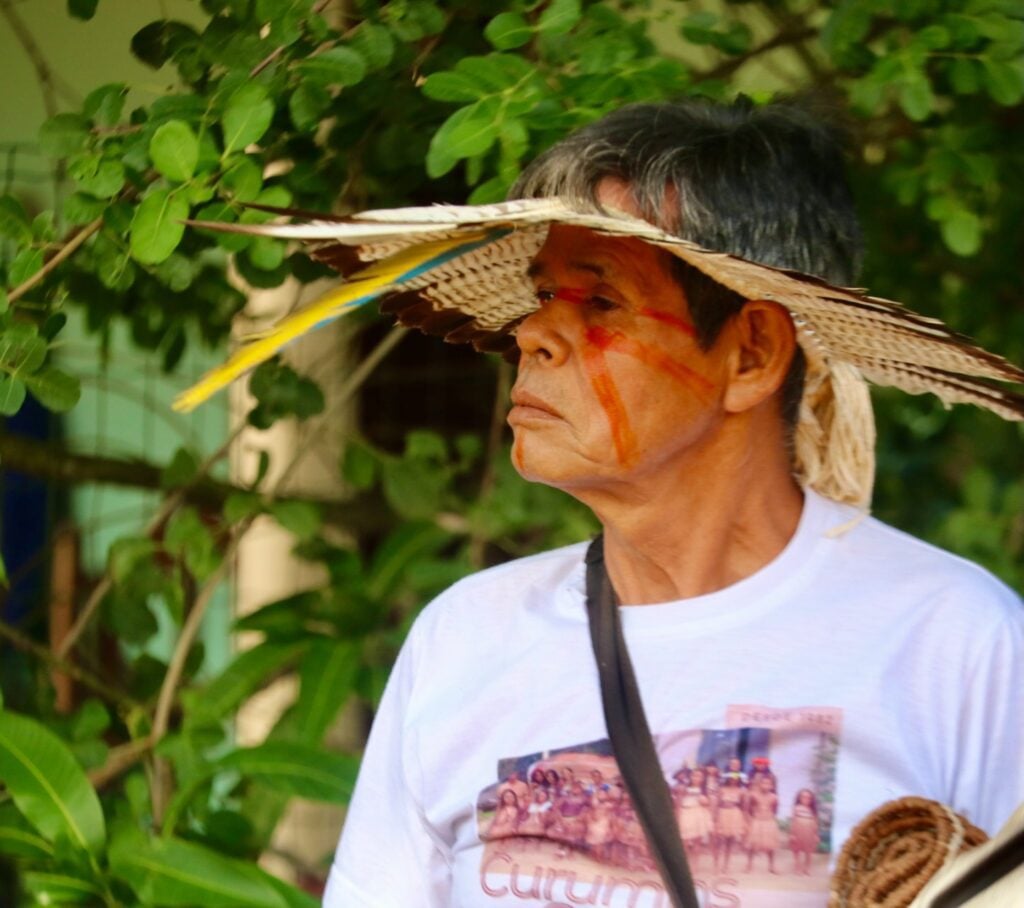 Imagem de um homem indígena de cocar.