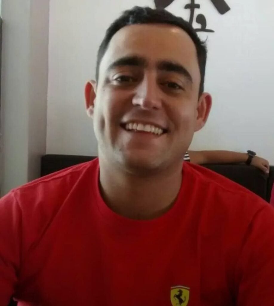 Imagem de um homem sorridente em uma sala de estar.