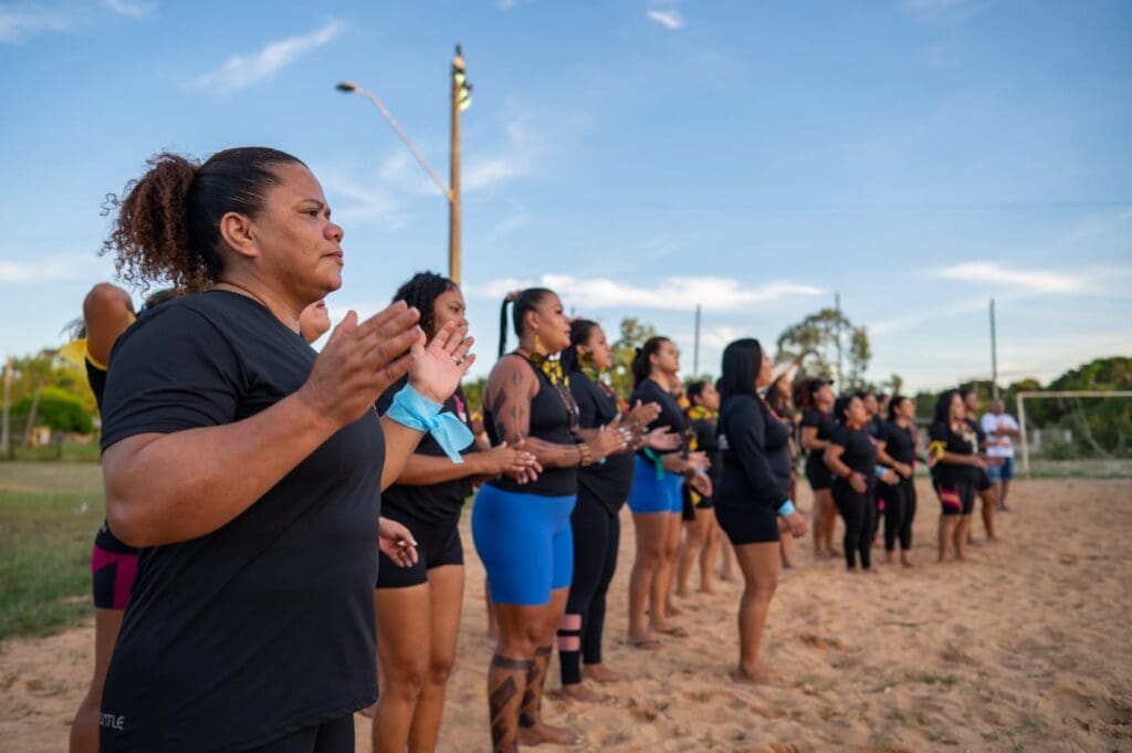 Grupo de mulheres reunidas em uma fila durante um evento do Coletivo Vem Com Elas.