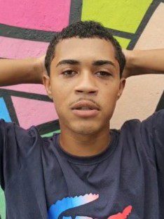 Imagem de um homem (Júlio César Lima Anatório Vieira Cabidelle, 19 anos. com as duas mãos na cabeça pousando para uma foto.