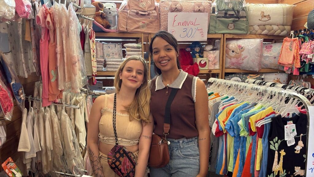 Imagem de duas mulheres em frente a uma loja de roupas durante o Liquida Cariacica 2025.