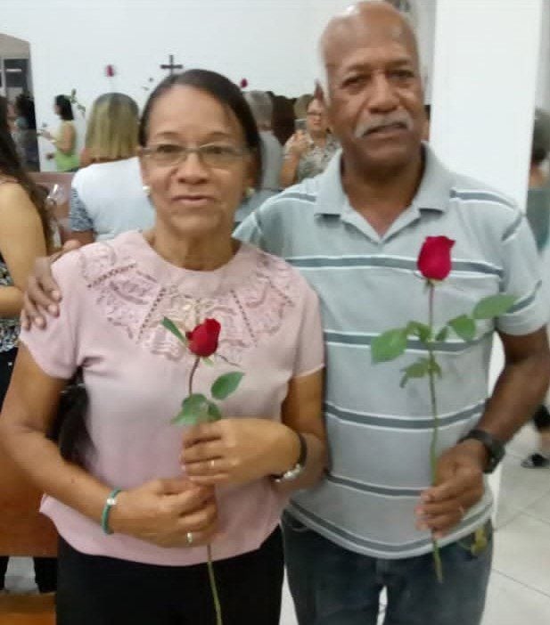 Imagem de um casal de idosos segurando uma rosa.