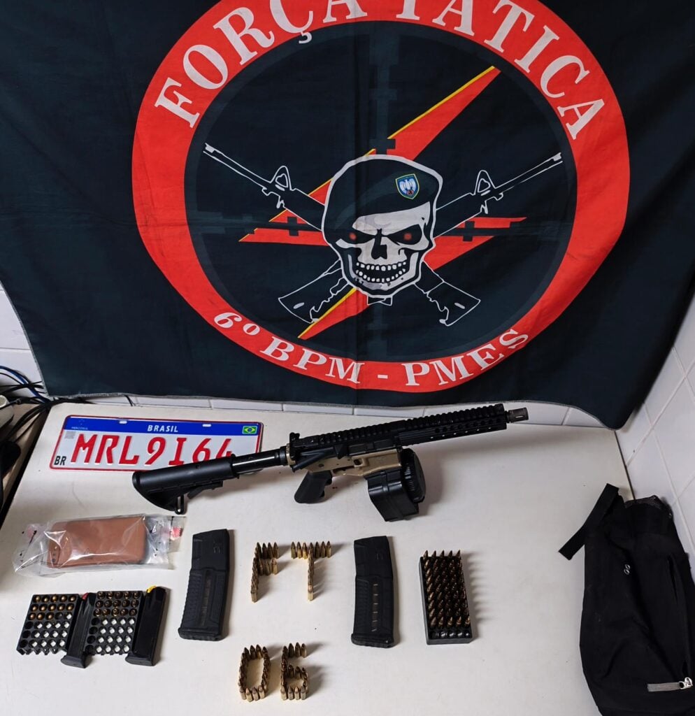 Foto de uma apreensão: Uma carabina Colt M4 calibre 5,56, com carregador de alta capacidade e 50 munições; dois carregadores de fuzil calibre 5,56, com 30 munições cada; um carregador de pistola calibre 9mm com 15 munições; um carregador de pistola calibre .380 com 13 munições; além de uma placa veicular.